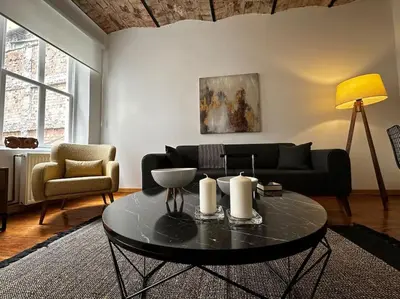 a living room with a black couch and a table at Historical Flat in Galata - Tatar Beyi Street - TRA 2026 Award-Winner in Istanbul