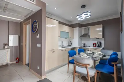 a kitchen and dining room with a table and blue chairs at MELVİN HOMe in Istanbul