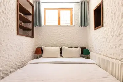 a bedroom with a bed with white sheets and a window at Authentic 1BR w Private Patio in Hype Cihangir in Istanbul