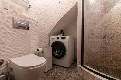 a bathroom with a toilet and a washing machine at Authentic 1BR w Private Patio in Hype Cihangir in Istanbul