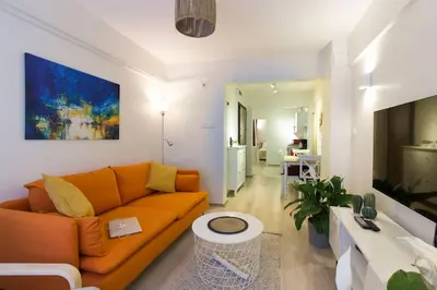 a living room with an orange couch and a table at Fully Renovated 2BR Flat in Prime Location at Moda in Istanbul