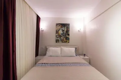 a bedroom with a bed with a painting on the wall at Fully Renovated 2BR Flat in Prime Location at Moda in Istanbul