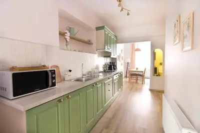 a kitchen with green cabinets and a microwave at Soft modern inspiring flat in the center of Moda in Istanbul