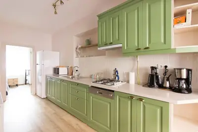 a kitchen with green cabinets and a white refrigerator at Soft modern inspiring flat in the center of Moda in Istanbul