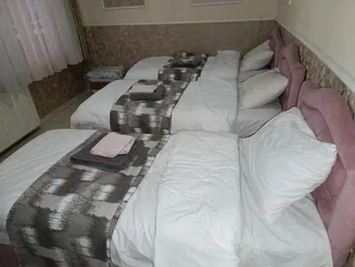 a large bed with white sheets and pillows on it at Merkez İstanbul in Istanbul
