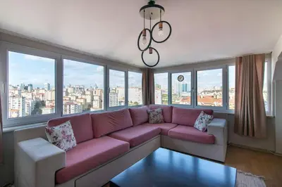a living room with a pink couch and large windows at Charming 2BR Panoramic Views Penthouse in Maltepe in Istanbul