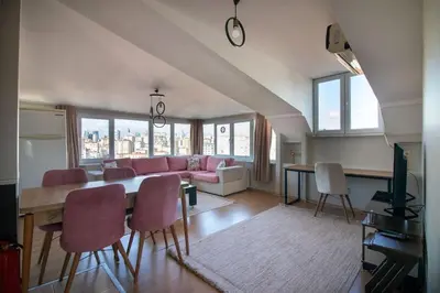 a living room with a table and a pink couch at Charming 2BR Panoramic Views Penthouse in Maltepe in Istanbul
