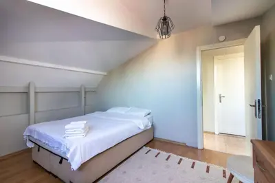 a bedroom with a bed with white sheets and a door at Charming 2BR Panoramic Views Penthouse in Maltepe in Istanbul