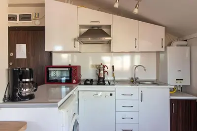 a kitchen with white cabinets and a red microwave at Charming 2BR Panoramic Views Penthouse in Maltepe in Istanbul