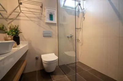 a bathroom with a toilet and a glass shower at 2BR Flat W Modern Touches in Adalar