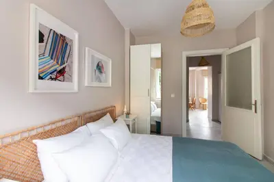a bedroom with a white bed and a hallway at 2BR House W Island Charm in Adalar