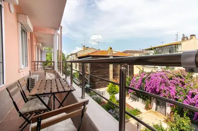 a balcony with a bench and flowers on a building at 2BR House W Island Charm in Adalar