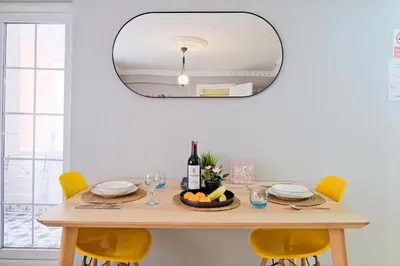 a dining room table with yellow chairs and a round mirror at Taksim İstiklalin Kalbinde Konforlu Daire Netflix Wifi in Istanbul