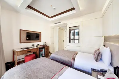 a hotel room with two beds and a tv at Grand Hotel de Pera in Istanbul