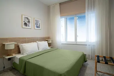 a bedroom with a green bed and a window at Bright and Cozy 2BR Apt In The Center Of Buyukada in Adalar
