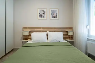 a bedroom with a large green bed with two lamps at Bright and Cozy 2BR Apt In The Center Of Buyukada in Adalar