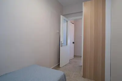 a bedroom with a bed and a door to a hallway at Bright and Cozy 2BR Apt In The Center Of Buyukada in Adalar