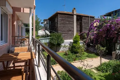 a balcony of a house with benches and flowers at Bright and Cozy 2BR Apt In The Center Of Buyukada in Adalar