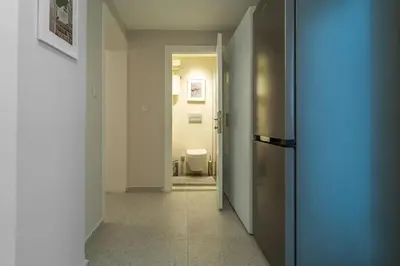 a hallway with a refrigerator and a toilet in a room at 2BR Designed Flat In The Center of Buyukada in Adalar