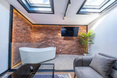 a bathroom with a large tub and a couch at Hexa Apartments Sisli in Istanbul