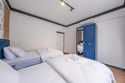 a bedroom with two beds and a blue door at Hexa Apartments Sisli in Istanbul