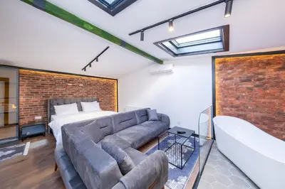 a brick walled bedroom with a couch and a bed at Hexa Apartments Sisli in Istanbul