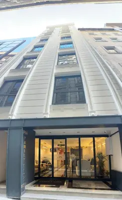 a large white building with glass windows at Şişli Family Time Suites in Istanbul