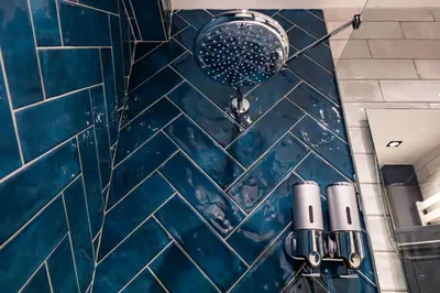 a shower in a bathroom with blue tiles at Şişli Family Time Suites in Istanbul