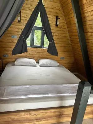 a bed in a wooden room with a window at Happy Enjoy Bungalow in Sapanca