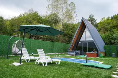 a group of chairs and an umbrella next to a pool at Happy Enjoy Bungalow in Sapanca