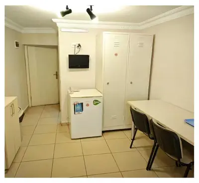 a kitchen with a table and a white refrigerator at Hostelist in Istanbul