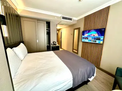 a bedroom with a large bed and a tv on a wall at Aven Hotel in Istanbul