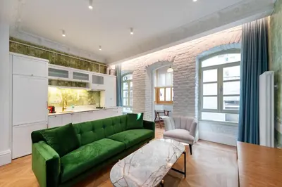 a living room with a green couch and a kitchen at Liberty Residence in Istanbul