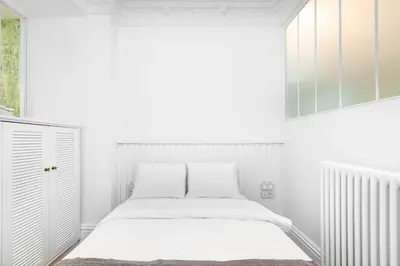 a white bedroom with a bed and a window at Liberty Residence in Istanbul