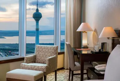 a hotel room with a desk and a room with a tower at Kaya İstanbul Fair & Convention in Istanbul