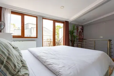 a large white bed in a room with windows at Modern Suites Galata in Istanbul