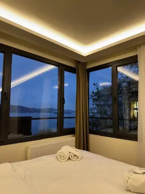 a bedroom with a large window with towels on a bed at Lokka Hotel Ortakoy in Istanbul