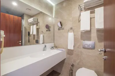a bathroom with a sink and a large mirror at Park by Clover Nişantaşı Harbiye Şişli in Istanbul