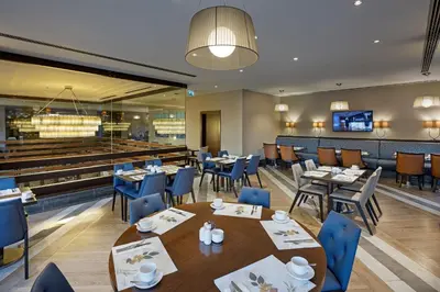 a restaurant with tables and chairs and a bar at Titanic City Taksim in Istanbul