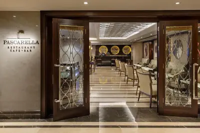 a lobby of a restaurant with glass doors and chairs at Titanic City Taksim in Istanbul