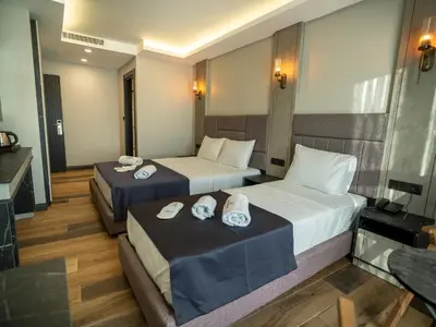 two beds in a hotel room with towels on them at Modernlux Hotel in Istanbul