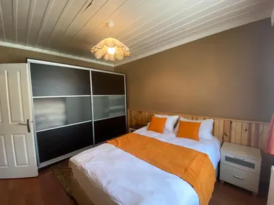 a bedroom with a large bed and a chandelier at Serbesler Botanik, No 2 Mini House in Sakarya