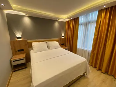 a bedroom with a large white bed and a window at Enjoy Suit in Tuzla
