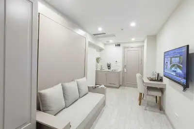 a white living room with a couch and a desk at Perla Galata Hotel in Istanbul