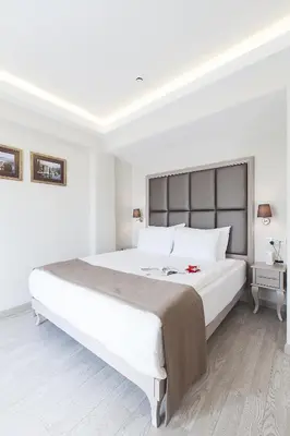 a white bedroom with a large white bed with white pillows at Perla Galata Hotel in Istanbul
