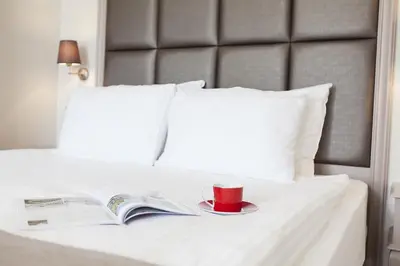 a book and a cup on a plate on a bed at Perla Galata Hotel in Istanbul