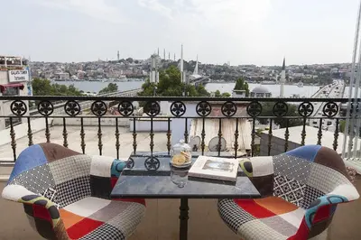 a table and chairs on a balcony with a view at Perla Galata Hotel in Istanbul