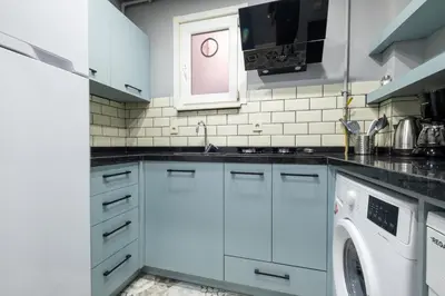 a kitchen with white cabinets and a washer and dryer at Mayer Beyoglu Apartments in Istanbul