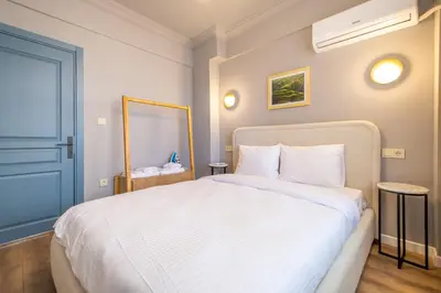 a bedroom with a white bed and a blue door at Mayer Beyoglu Apartments in Istanbul