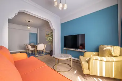 a living room with an orange couch and a tv at Mayer Beyoglu Apartments in Istanbul